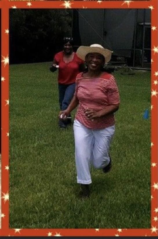 Two women are happily running across a green field, enjoying a cheerful day outdoors.