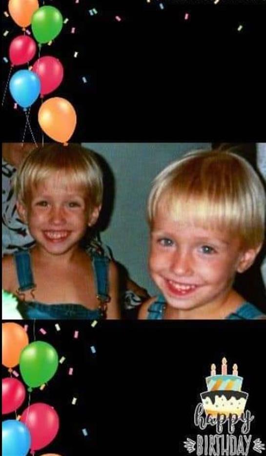 Two happy twin kids smile at a fun birthday party filled with colorful balloons.