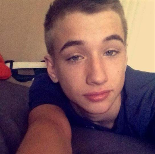 Teenager lies on a couch, looking relaxed and thoughtful in a comfortable space.