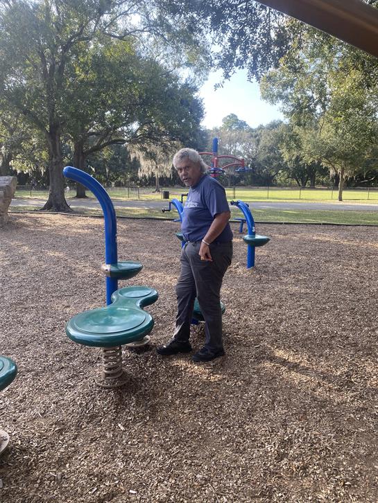 At an outdoor park, an individual engages with fitness equipment, enjoying morning exercise.