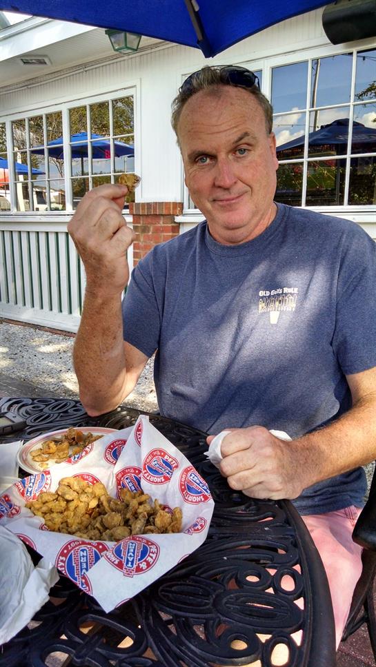Savoring a variety of fried delicacies while sitting outdoors with friends during a sunny afternoon.