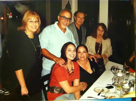 Friends and family enjoy a joyful dinner together, sharing laughter and conversation at a table.