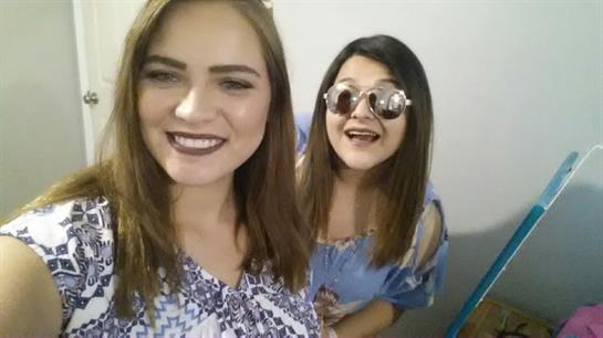 Two friends are smiling and posing, celebrating their bond and enjoying a lighthearted atmosphere.