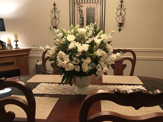 A stunning display of white flowers brightens the dining room table, adding charm and elegance.