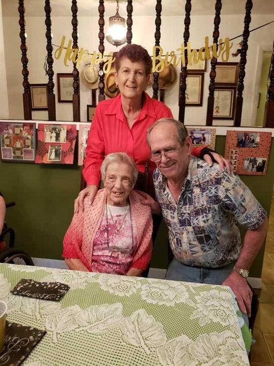 Several family members gather together, smiling joyfully in a comfortable home environment.