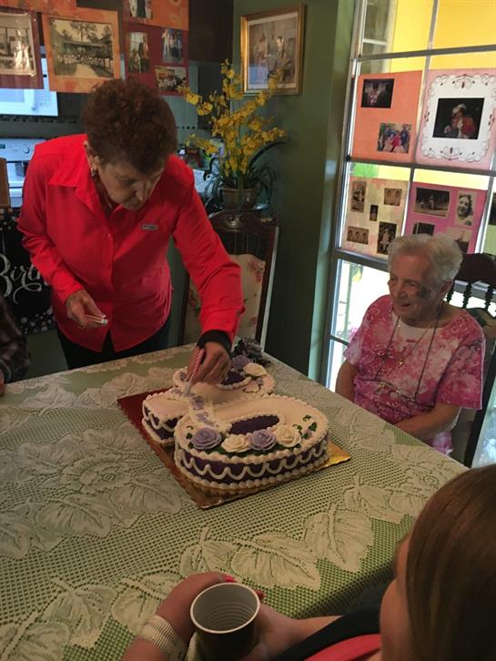 Friends gather to celebrate, enjoying cake and laughter in a warm and inviting room.