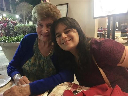 Two women enjoy each other's company while seated at a table in a cozy restaurant.