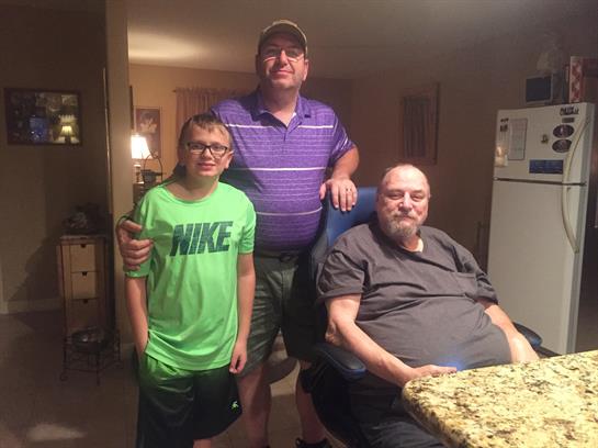 Three family members smile in a warm living room, sharing moments and creating memories together.