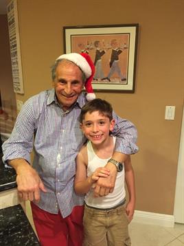 Grandfather and grandson celebrate the holidays together in their cheerful kitchen.