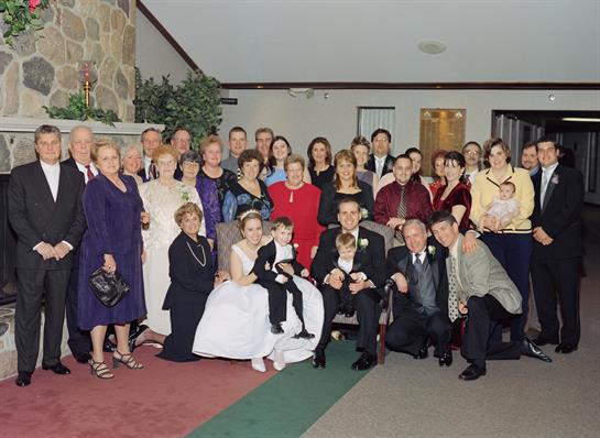Family and friends joyfully celebrate a wedding in a stylish banquet hall.