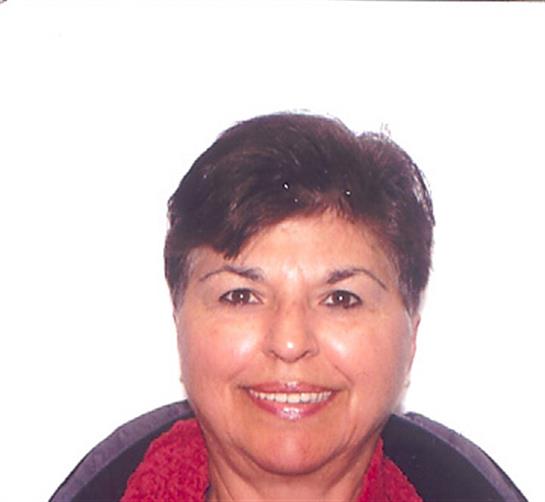 A woman with short dark hair smiles warmly in a red scarf, exuding positivity and confidence.
