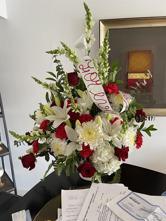 A vibrant arrangement of red roses, white lilies, and greenery enhances the elegant atmosphere.