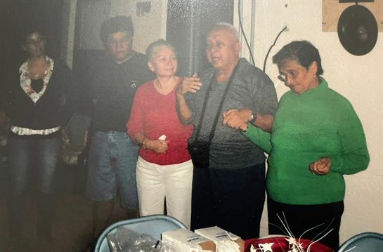 Family members hold hands, enjoying a warm moment during a festive gathering in the evening.