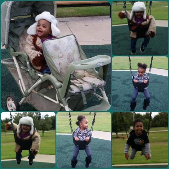 A cheerful child swings and smiles while playing in a park during a sunny day.