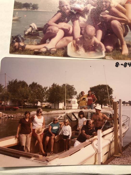 Group of friends gather around a boat and shoreline, sharing laughter and good times outdoors.