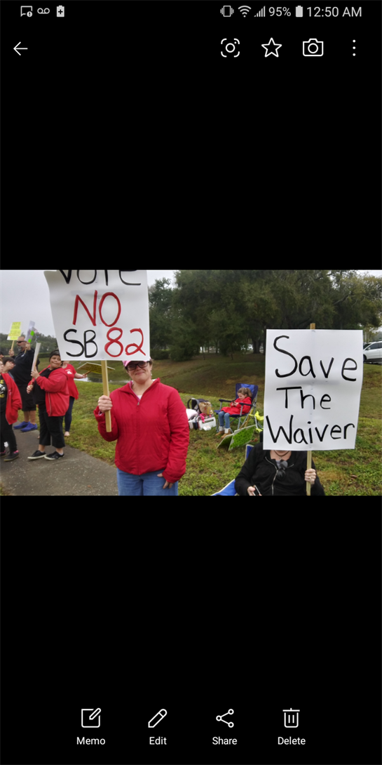 Community members gather with signs to protest against SB 82, advocating for important local issues.