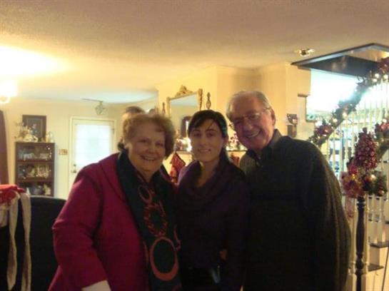 Family members share joyful moments together in a warm living room during a festive celebration.