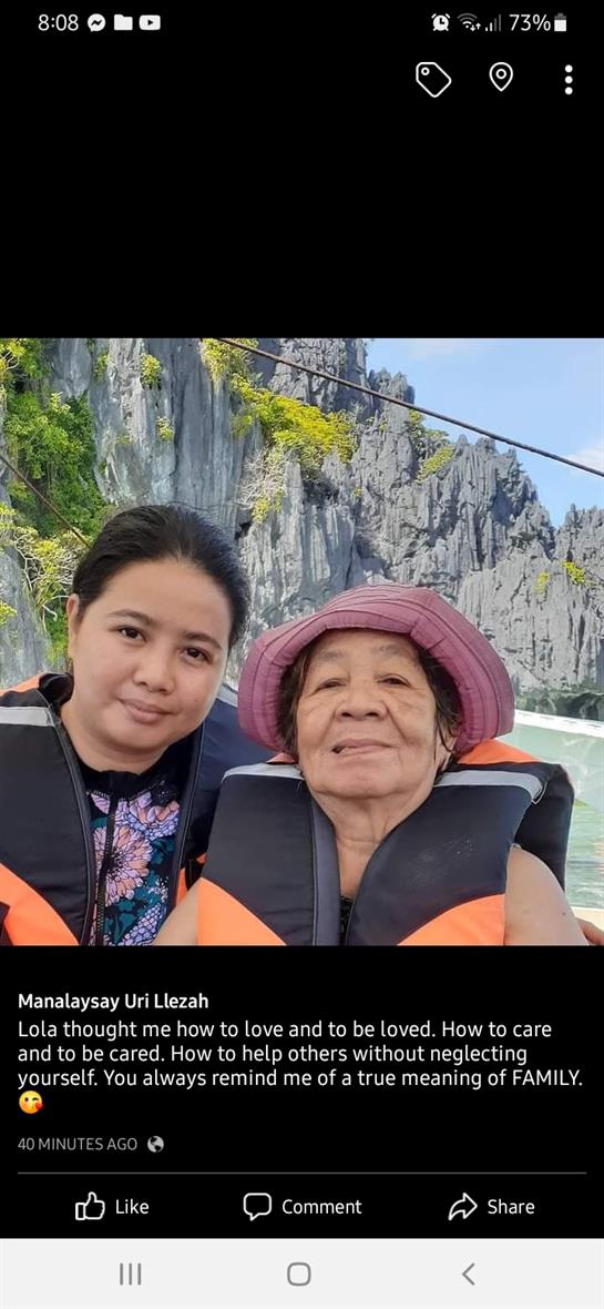 Two women smile while wearing life jackets on a boat, surrounded by rocky formations and greenery.