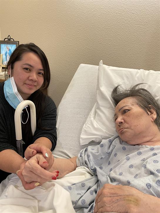 A nurse offers companionship to an elderly patient in a hospital room, ensuring comfort and care.