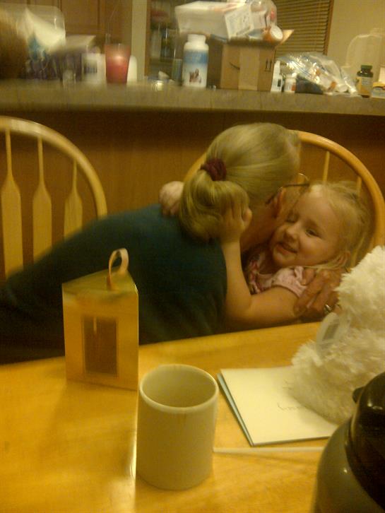 A grandmother and granddaughter share a joyful hug, surrounded by a warm, inviting cafe atmosphere.