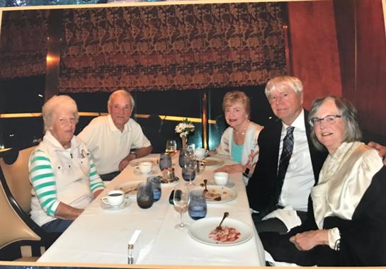 Friends gather around a table filled with dishes, sharing stories and laughter during dinner.