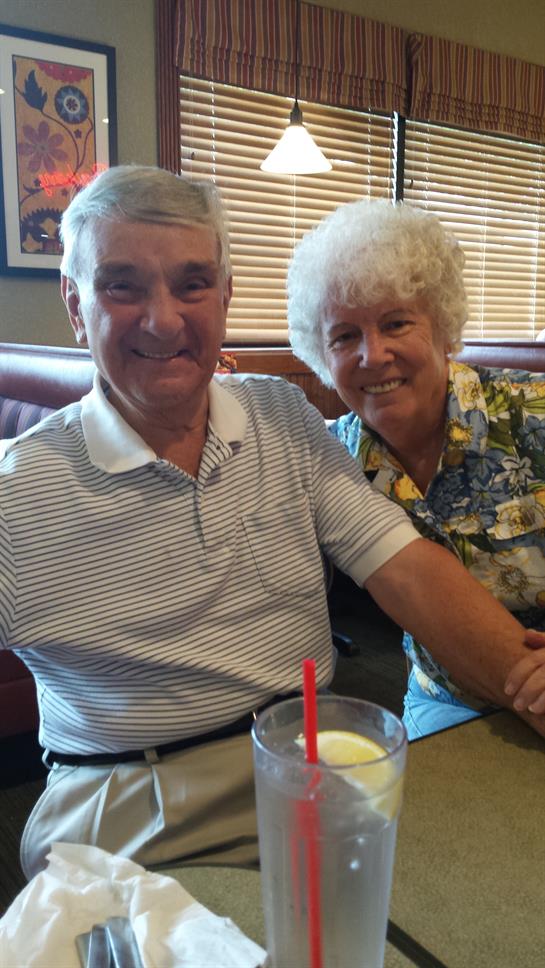 Happy couple shares a joyful moment in a diner while sipping refreshing drinks and smiling.