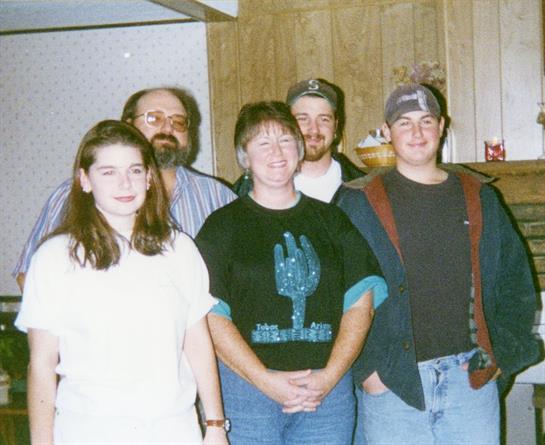 Five friends share laughter and joy together in a cozy kitchen.
