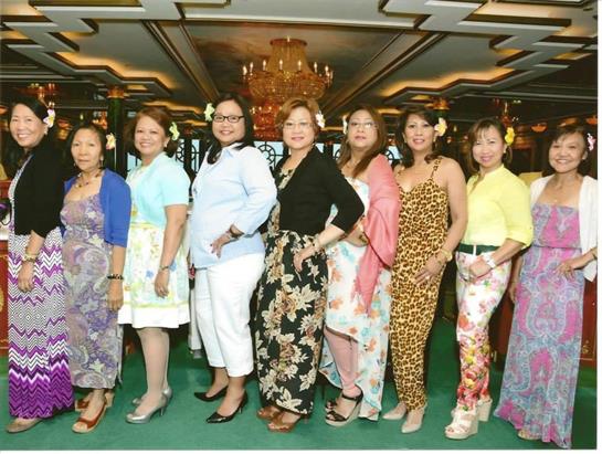 Women gather in colorful outfits, enjoying each other's company during a lively celebration.