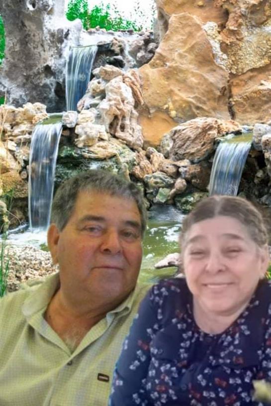 Couple enjoys a joyful moment with a beautiful waterfall in the background during the day.