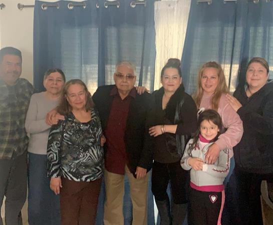 Extended family enjoys quality time together in a warm living room setting, embracing each other.
