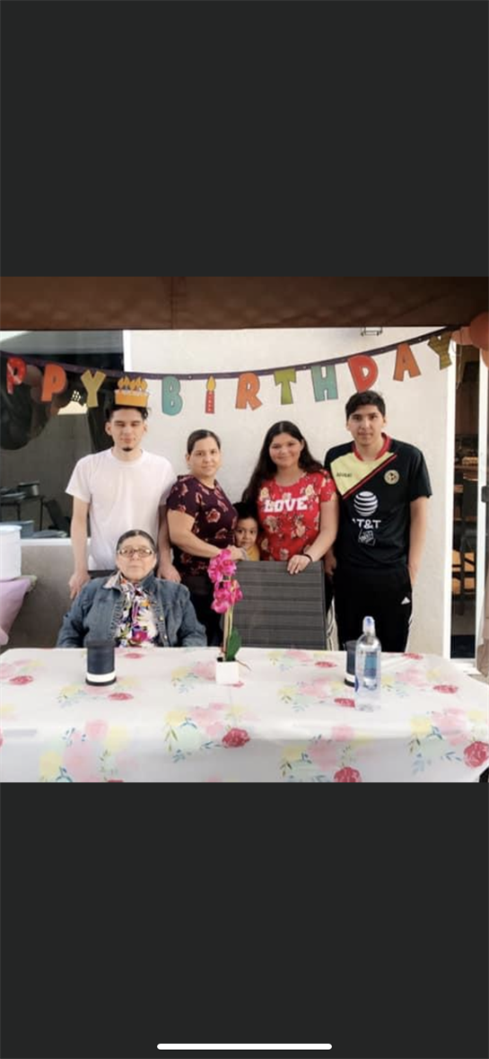 Family members gather around a decorated table to celebrate a birthday, filled with joy and smiles.