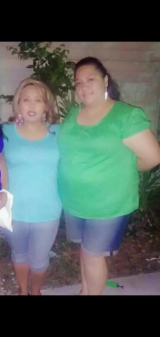 Two friends smile together outdoors, wearing vibrant tops and enjoying their time.