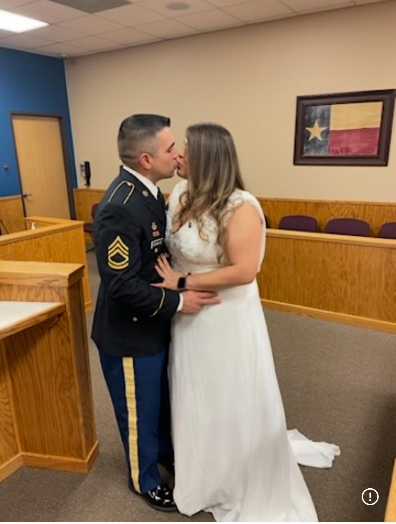 Newlyweds share a kiss at the courthouse in Texas, celebrating their marriage in casual attire.