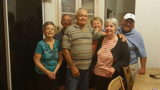 A group of friends smiles and poses together in a warm home, celebrating friendship and memories.