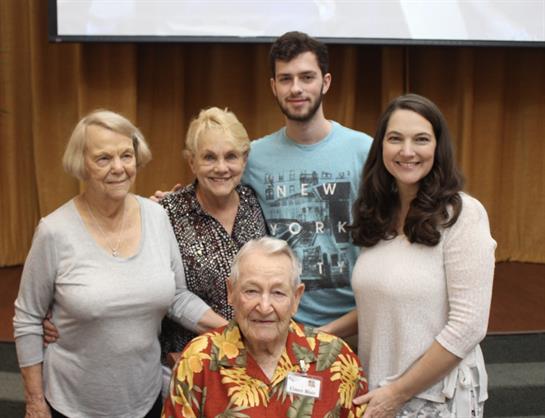 Five family members pose together, smiling, highlighting joy and connection during an event.