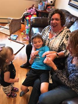 Laughter and joy fill the room as children interact with adults during a family gathering.