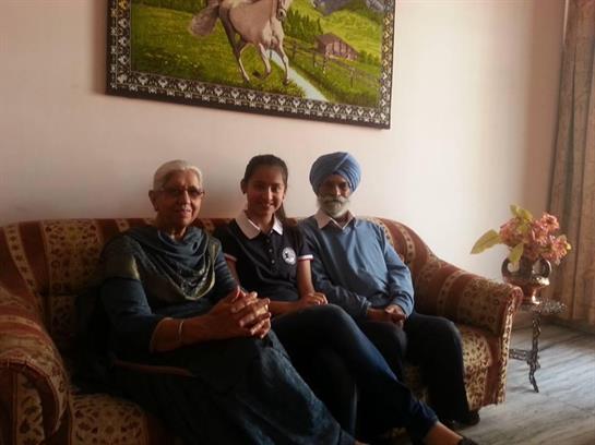 Three family members sit together comfortably, sharing stories in a welcoming living room.