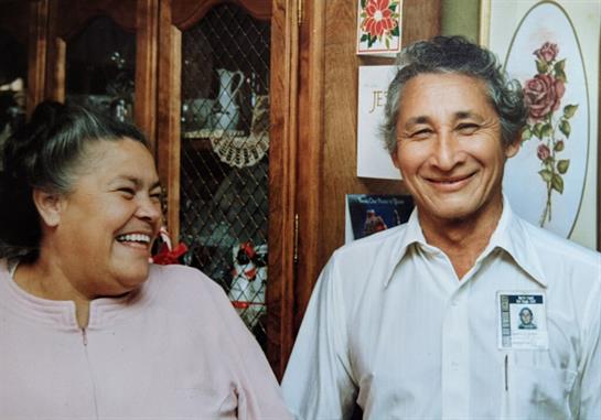 A joyful couple shares laughter and smiles inside a cozy home, creating cherished memories.