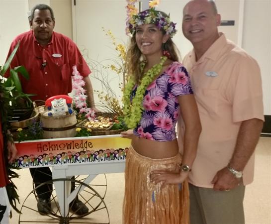 Hawaiian-themed gathering features guests in traditional attire and vibrant decorations.