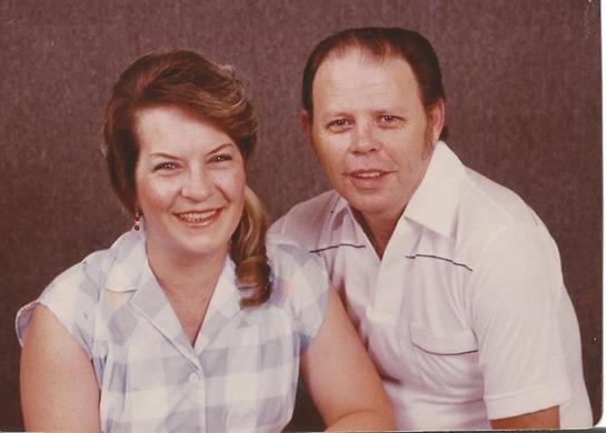 A smiling couple poses closely together at a photo studio, showcasing their joy and connection.