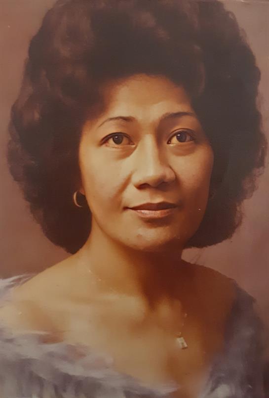 Woman with curly hair and subtle makeup gazes warmly, showcasing a calm and serene demeanor.