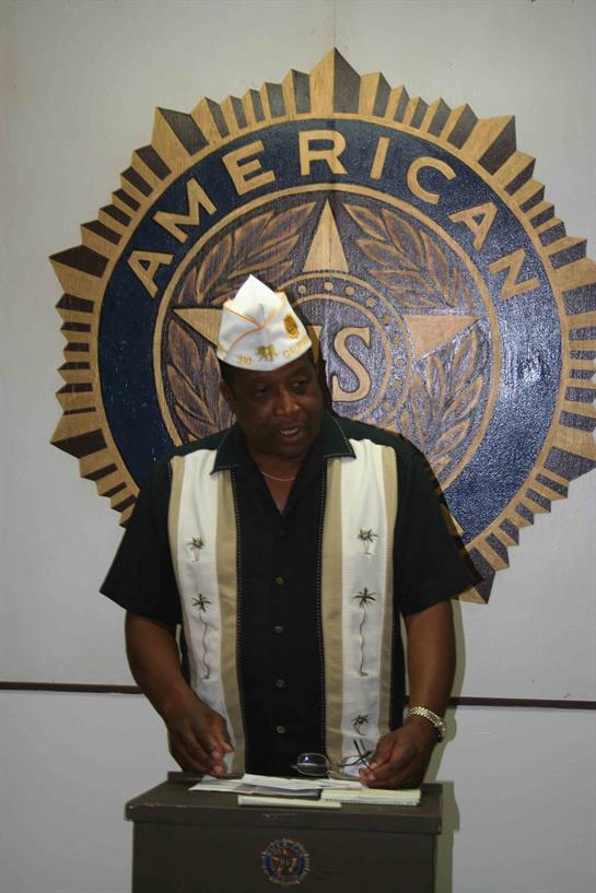 A participant in traditional attire engages with attendees at a local veteran event.