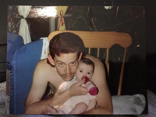 A parent lovingly holds an infant while feeding, surrounded by a warm, inviting atmosphere.