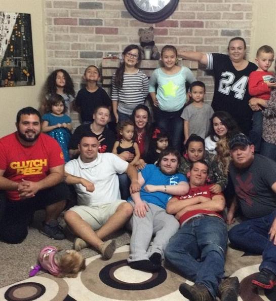 Family and friends enjoy each other's company in a lively living room filled with laughter and joy.