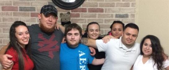 Group of friends posing together with smiles in a relaxed indoor environment at home.