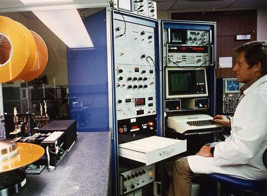 Researcher operates scientific instruments in a laboratory focused on data analysis and experiments.