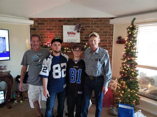 Family members pose together in a cozy living room adorned with holiday decorations.