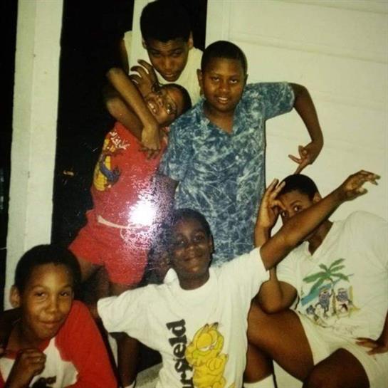 Six children are posing happily in a playful arrangement, showcasing joy and friendship.