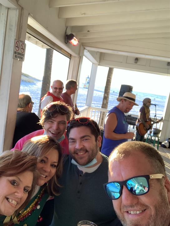 Friends gather together while enjoying a lively atmosphere and music on the waterfront.