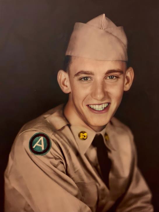 A young soldier smiles brightly, showcasing his uniform and embodying the spirit of service.